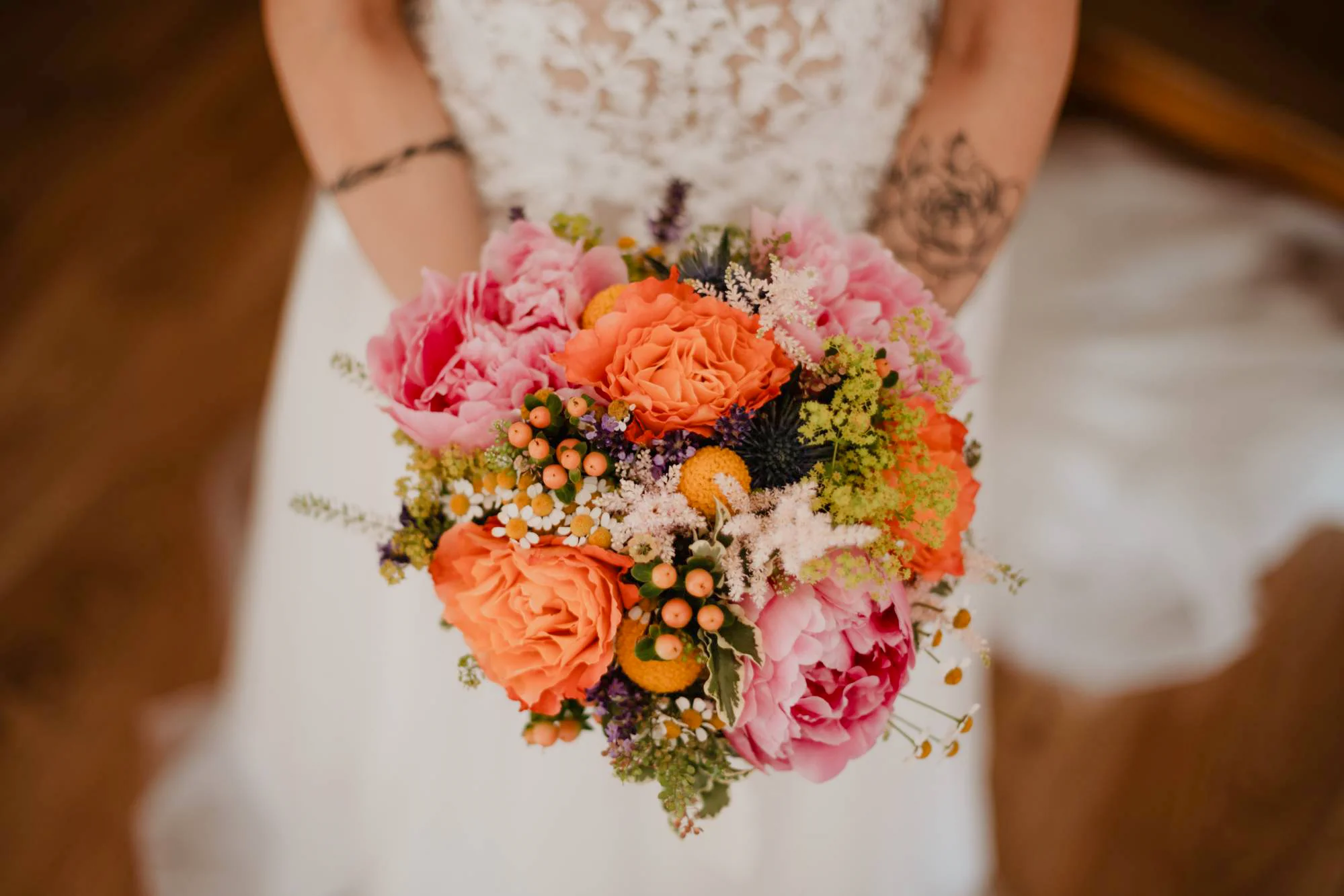 Una sposa tiene tra le mani il suo bouquet caratterizzato da fiori primaverili e colorati