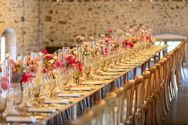 Allestimento per una tavolata di matrimonio caratterizzata da toni rosa e gialli